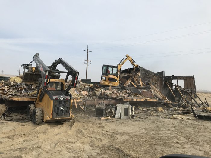 Excavators demolishing a commercial structure in Bakersfield