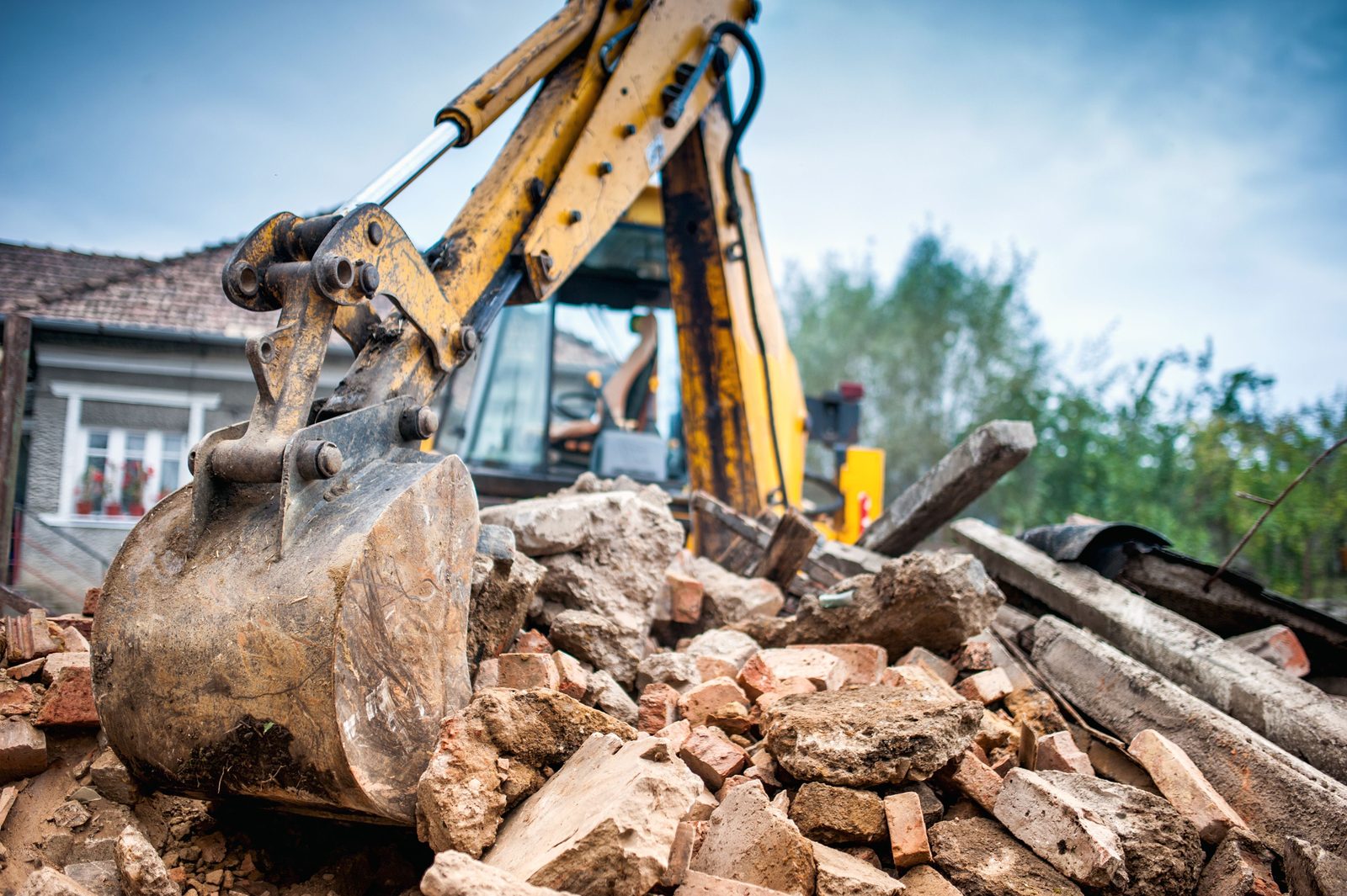 Excavator demolishing a structure on a Patterson and Sons Construction demolition job in Bakersfield