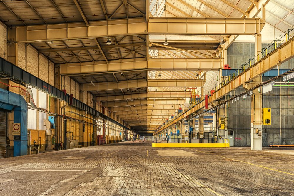 Industrial warehouse interior with structural steel bays and overhead lighting
