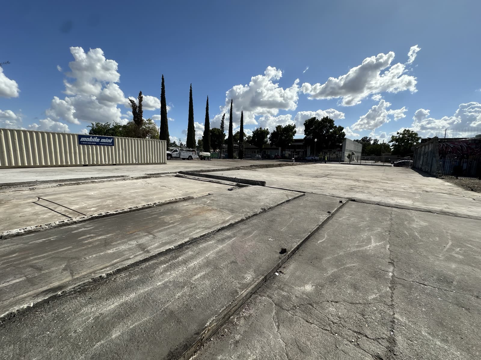 Saw joints and patched footings across the cleared slab marking where the demolished building stood