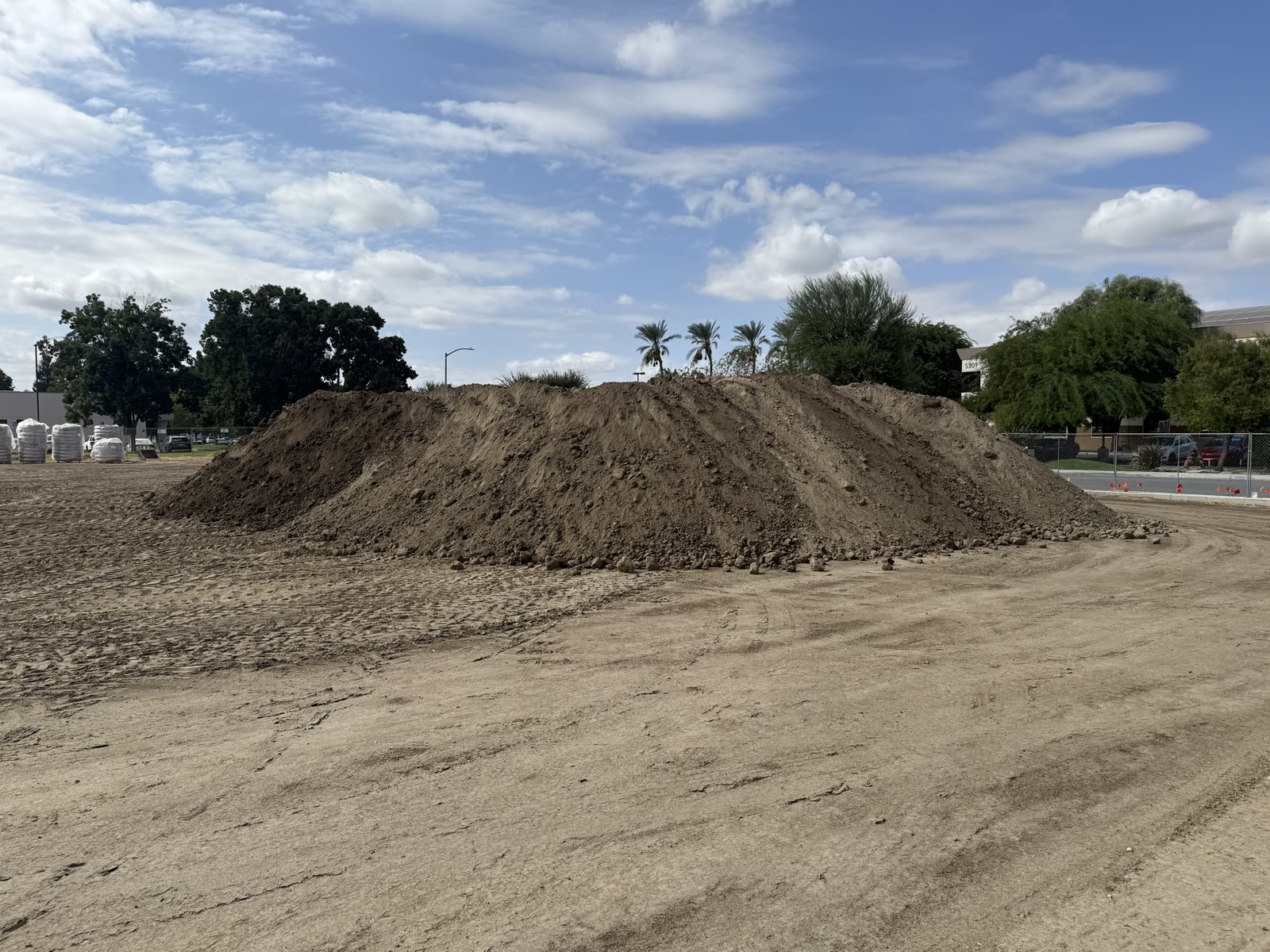 Commercial pad stripped and graded with the spoil stockpiled along the boundary fence