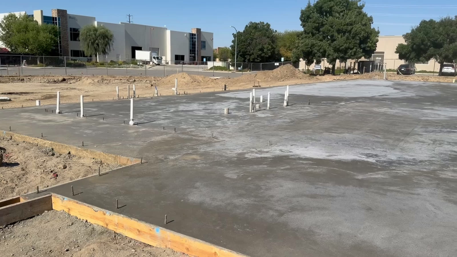 Finished concrete paving with dowels set, run out across a commercial parking area