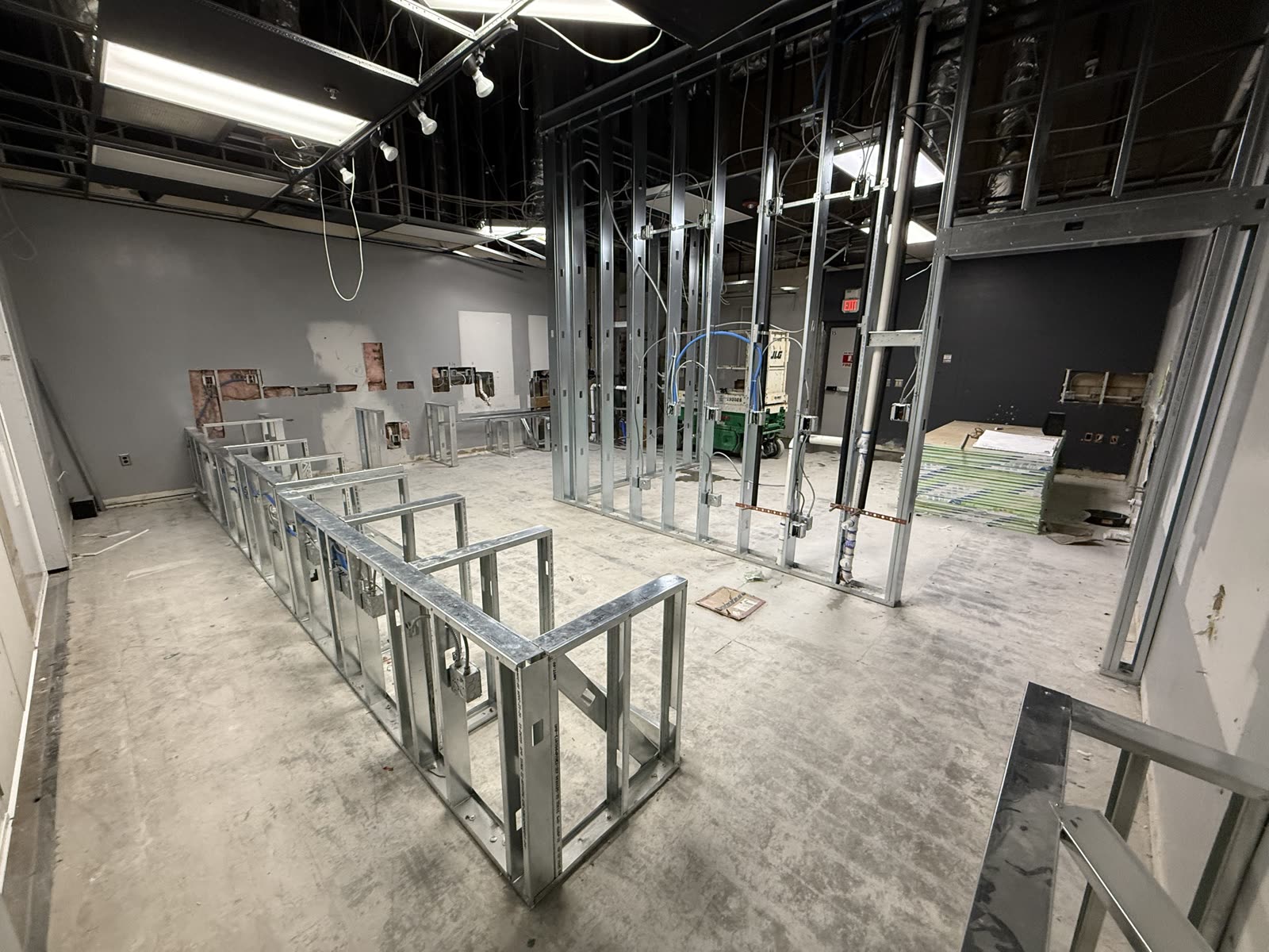 Commercial tenant space framed out in metal stud with the ceiling open and new services run overhead