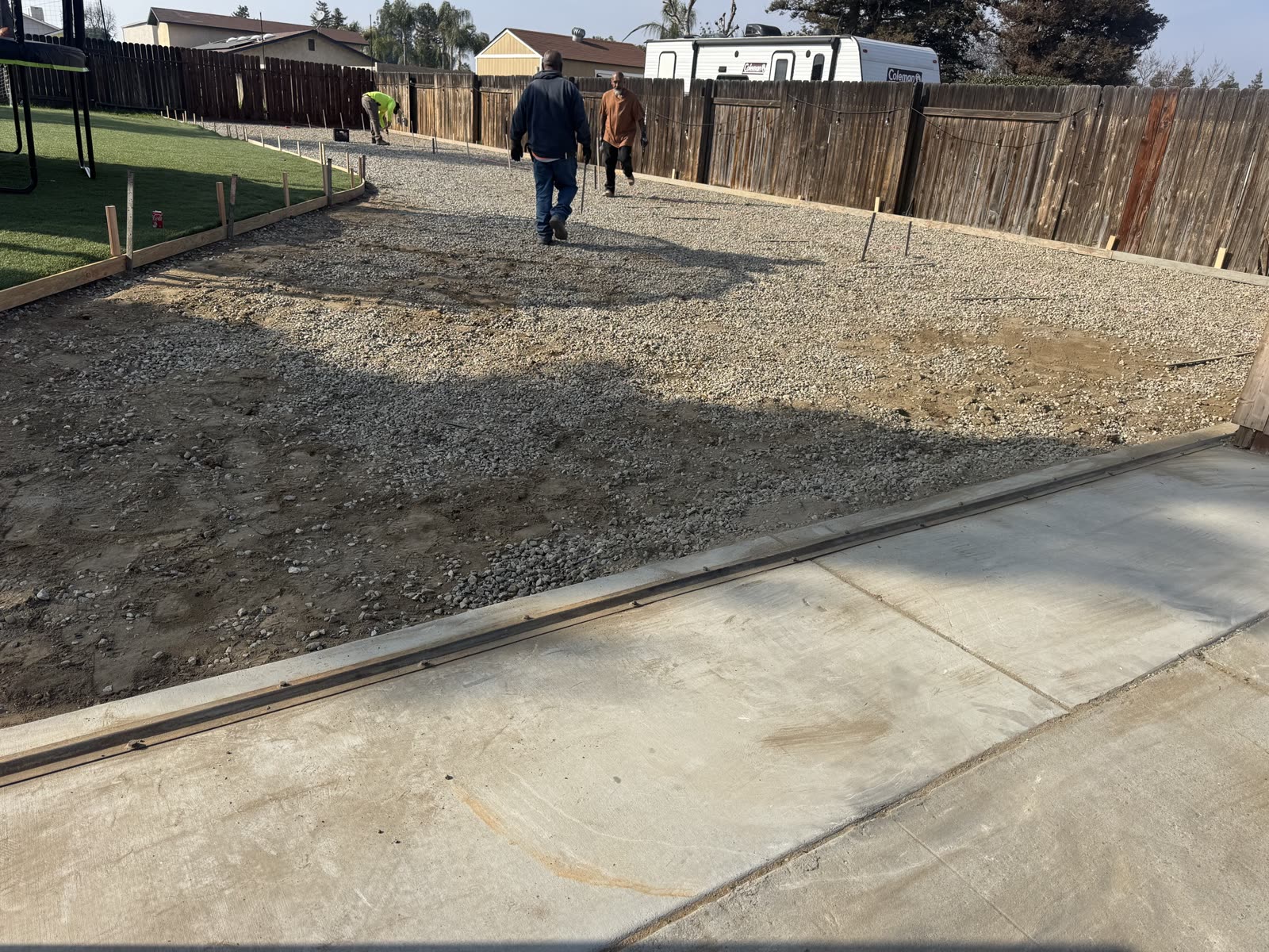 New pad edge formed hard against the existing concrete drive, ready for the pour