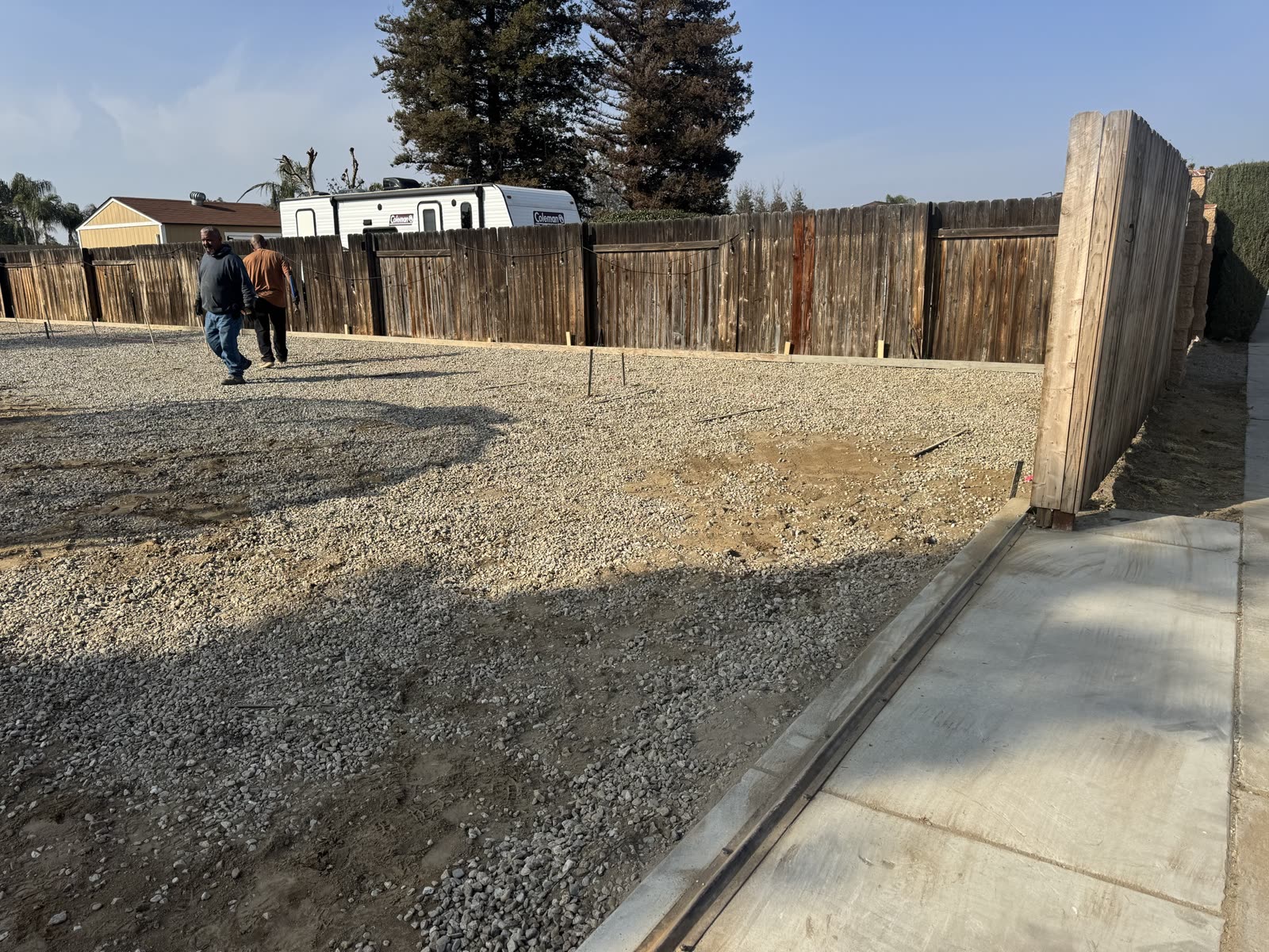 RV pad formed and filled with compacted base rock, tied into the existing drive at the gate