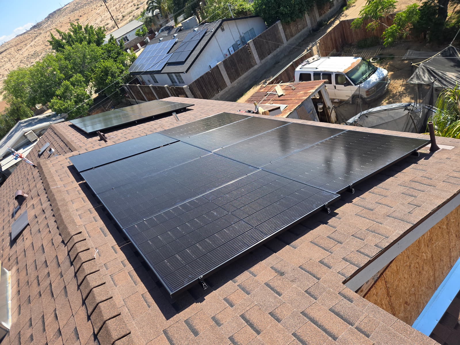 Completed rooftop solar array laid across the main roof plane above the neighborhood