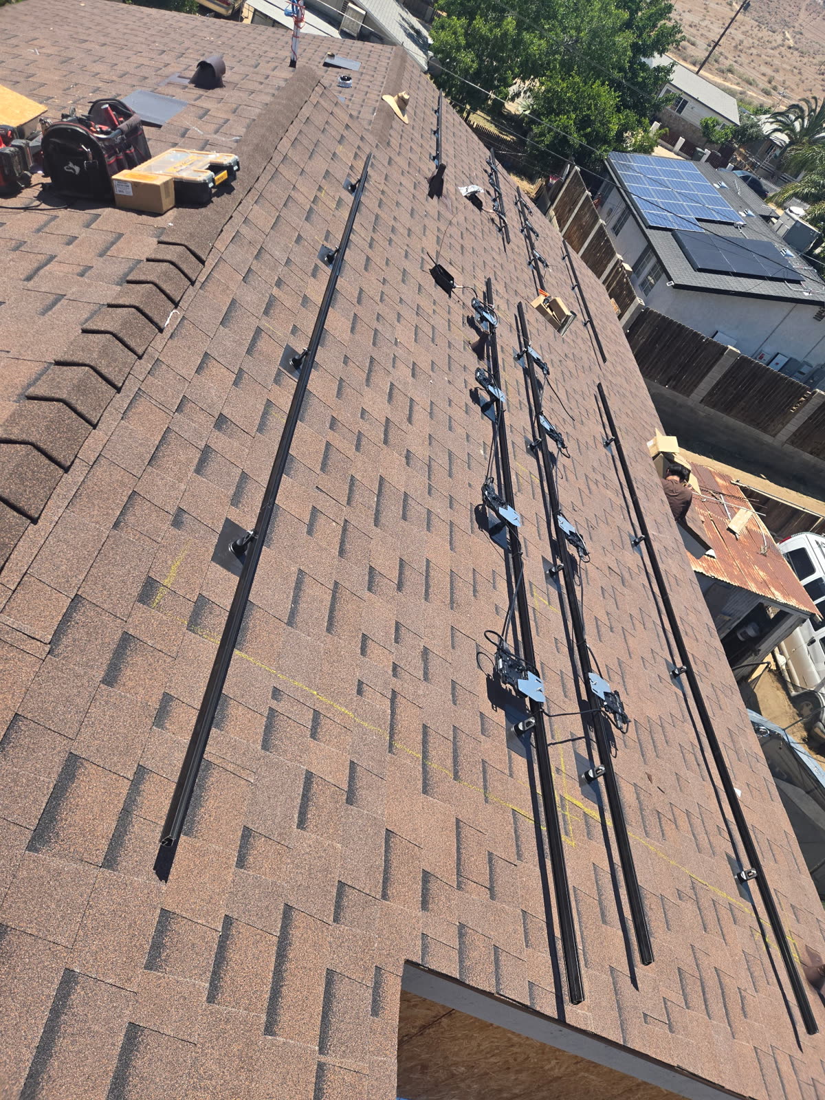 Mounting rails laid out and flashed into a composition shingle roof ahead of the solar panels