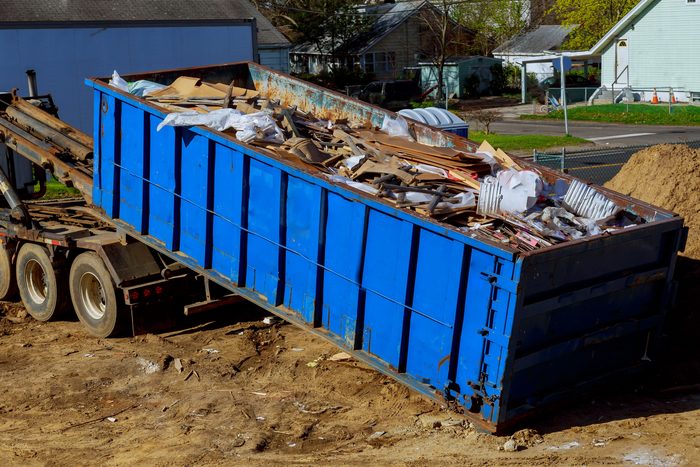 Roll-off container loaded with construction debris for haul-off